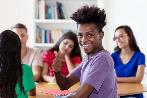 Succesvolle Afro-Amerikaanse mannelijke student leren met groep van — Stockfoto