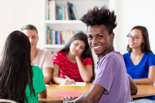 Studente afroamericano di sesso maschile che impara con un gruppo di studenti — Foto Stock