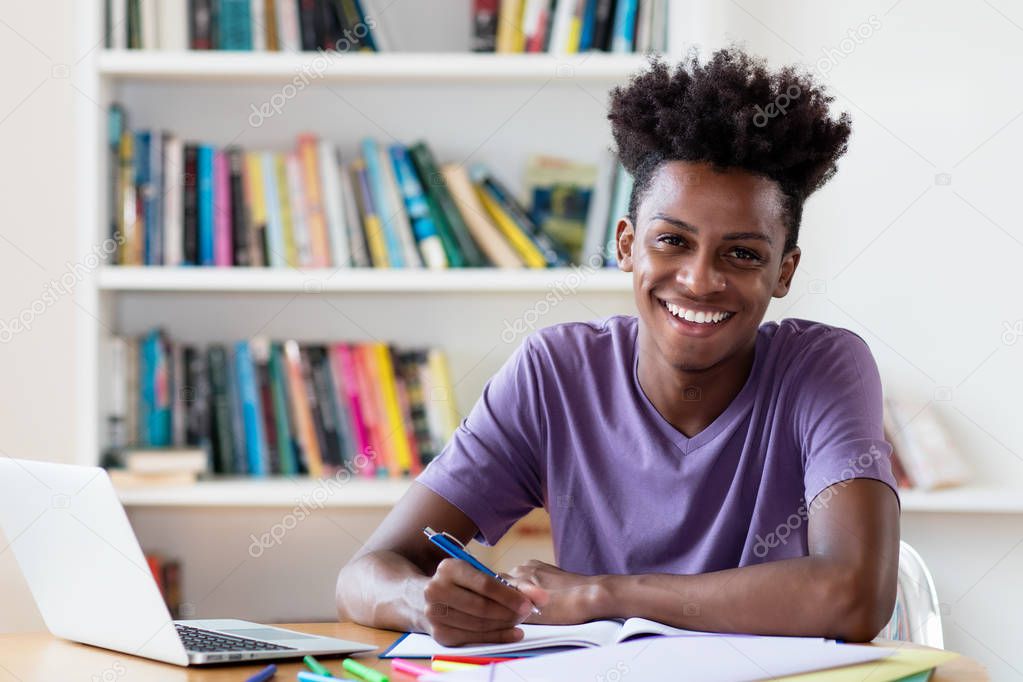 Laughing african american male student learning for diploma