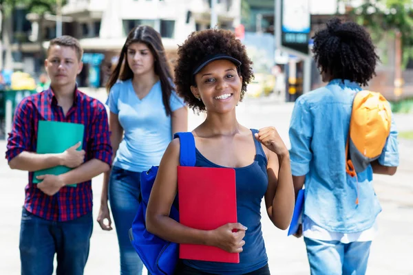 Feliz afro-americana jovem mulher adulta com estudantes na cidade — Fotografia de Stock