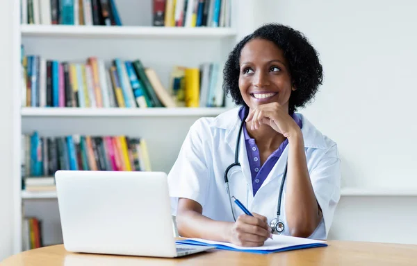 Сміється афроамериканська жінка-лікар на роботі — стокове фото