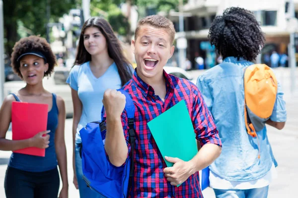 Jublande brasilianska manliga studenten med grupp av studenter — Stockfoto