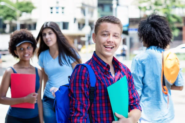 Skratta brasilianska manliga studenten med grupp av studenter — Stockfoto