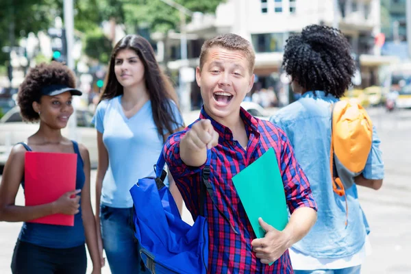 Lycklig brasiliansk manlig student med grupp av studenter — Stockfoto