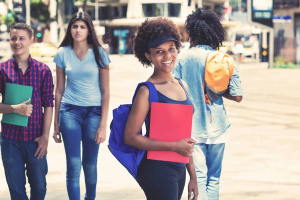 Jonge Afro-Amerikaanse vrouwelijke student wachten op bus — Stockfoto