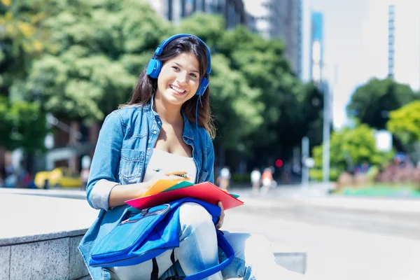 Kaukasische junge erwachsene Studentin mit Kopfhörer in der Stadt — Stockfoto