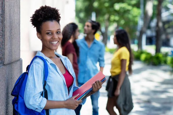 Smějící se africká americká studentka před univerzitou — Stock fotografie