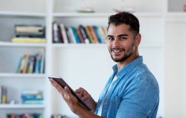 Tablet bilgisayar ile çalışan modern Meksikalı hipster adam