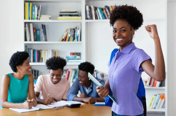 Cheering african american female young adult with students and t — Stock Photo, Image