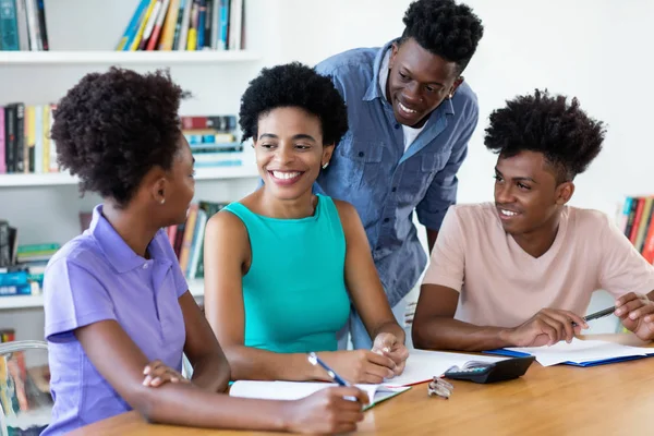 Mature female teacher with african american students — Stock Photo, Image