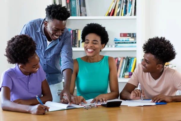 Smějící se africká americká školkyně vyučující studenty — Stock fotografie