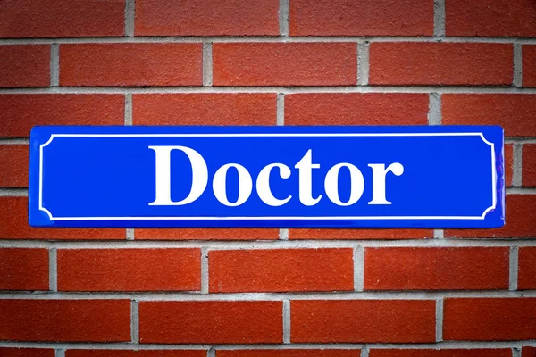 Doutor sinal de rua na parede de tijolo — Fotografia de Stock