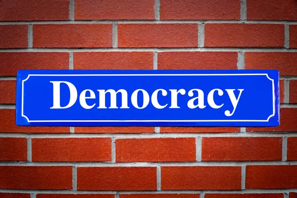 Democracy street sign on brick wall — Stock Photo, Image