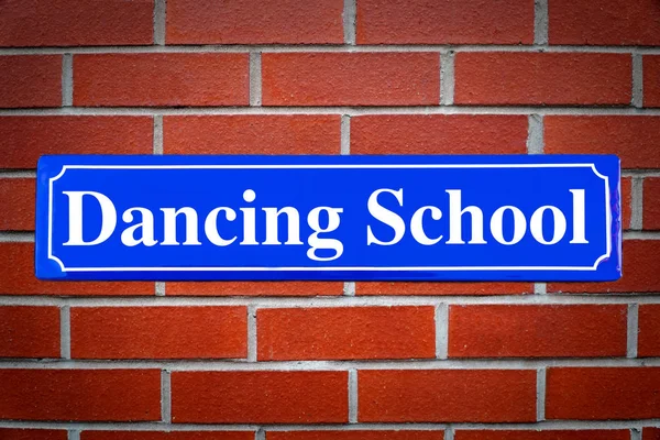 Dancing school street sign on brick wall — Stock Photo, Image