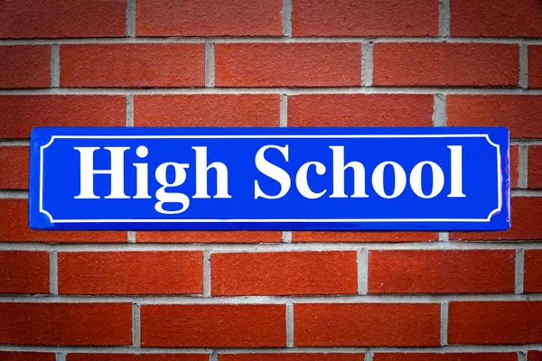 Straßenschild der High School an Ziegelmauer — Stockfoto