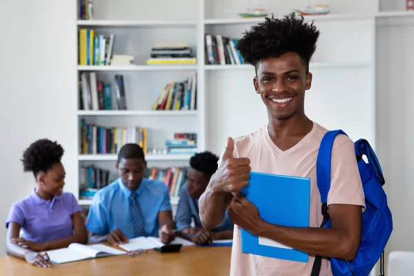 Lachender afrikanischer Student im Klassenzimmer mit einer Gruppe junger Erwachsener — Stockfoto