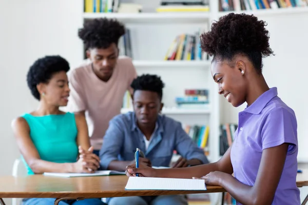 Junge afrikanisch-amerikanische Studentin lernt am Schreibtisch in der Schule — Stockfoto