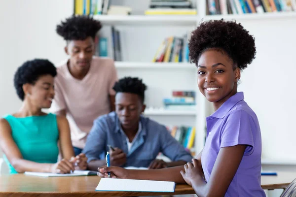 Schöne afrikanisch-amerikanische Studentin lernt am Schreibtisch bei sc — Stockfoto