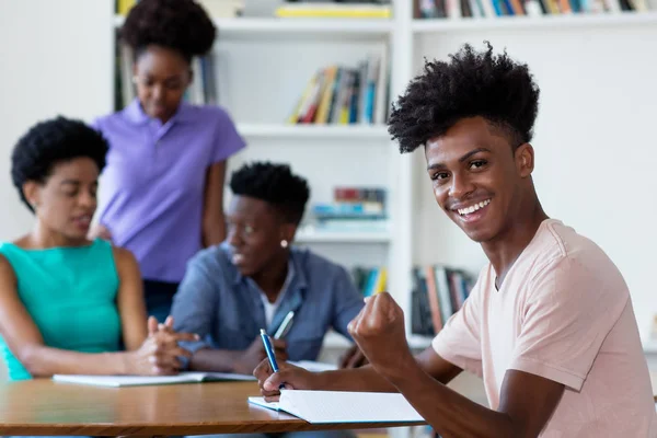 Successo afro-americano studente di sesso maschile apprendimento alla scrivania a sch — Foto Stock