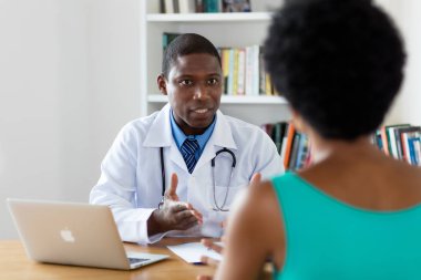 Afrikalı Amerikalı doktor hasta ile kanser hakkında konuşuyor