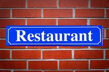 Tuğla duvarda restoran sokak işareti