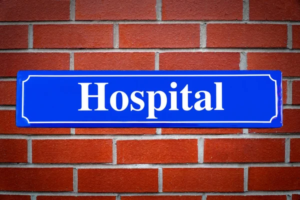 Hospital street sign on brick wall — Stock Photo, Image