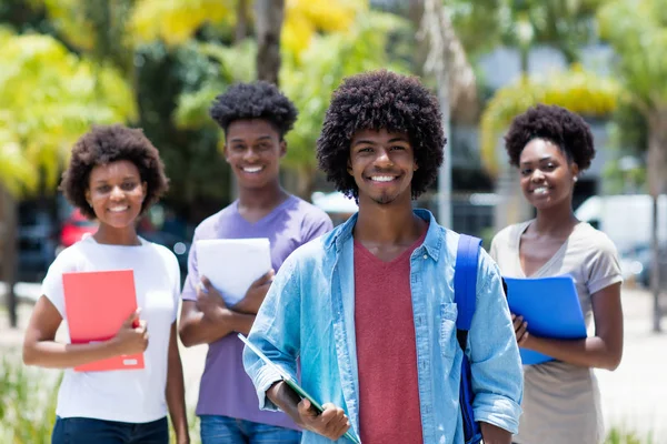 Estudante universitário afro-americano com grupo de américos africanos — Fotografia de Stock