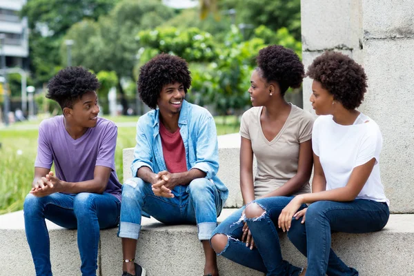 Group of talking african american young adults hanging out — Stock Photo, Image