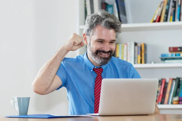 Cheering mature zakenman met baard geld verdienen met online — Stockfoto