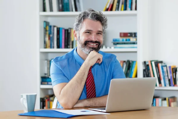 Riant mature homme d'affaires avec barbe travailler avec ordinateur à — Photo