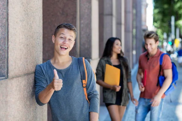 Caucásico joven adulto hombre en la ciudad con grupo de estudiantes — Foto de Stock