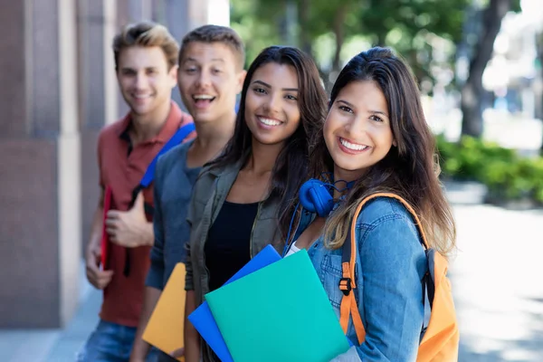 Kaukasische junge erwachsene Frau mit Studentengruppe in der Schlange — Stockfoto