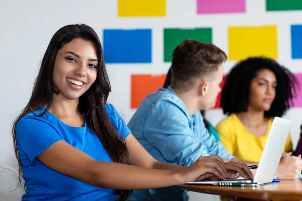 Studentessa ispanica che impara con un gruppo di studenti — Foto Stock