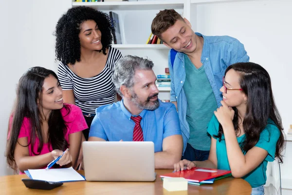Olgun erkek öğretmen çok etnik kolej s grubu ile konuşuyor