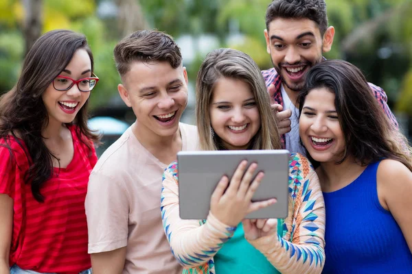 Estudante alemã com computador tablet e grupo de torcida — Fotografia de Stock