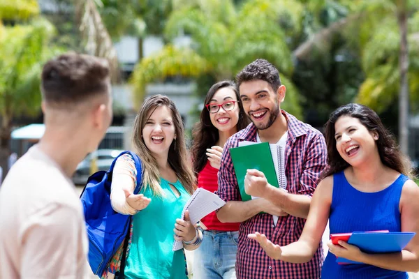 Group of international students congratulating to a german male