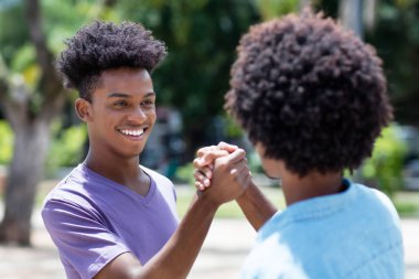Afrikalı Amerikalı genç yetişkin adam ile arkadaşa yüksek beş verir 