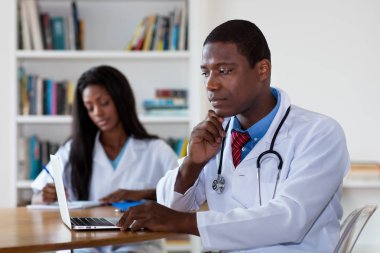 Afrikalı Amerikalı doktor hemşire ile iş başında