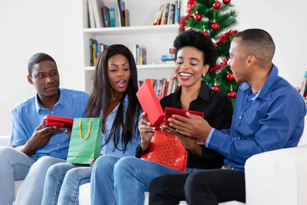 Laughing african african family celebrating christmas with gifts
