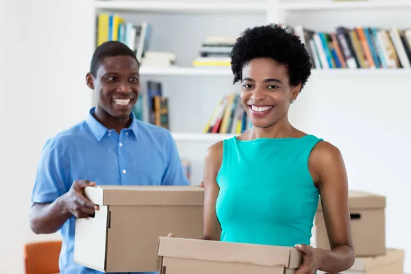 African american couple with boxes moving to new house — Stock Photo, Image