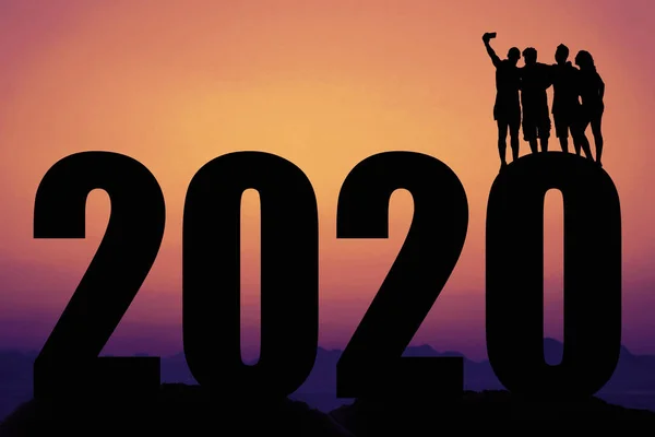 Puesta de sol con año nuevo 2020 y silueta de personas tomando selfie —  Fotos de Stock