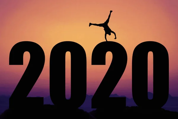 Sonnenuntergang mit Neujahr 2020 und Silhouette eines glücklichen Mannes — Stockfoto