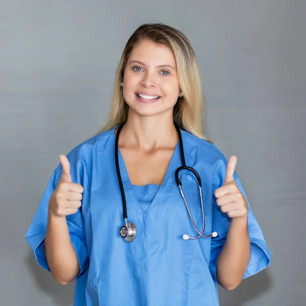 Portrait of beautiful blond nurse showing both thumbs up — Stock Photo, Image