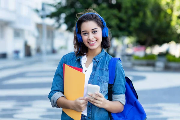 Estudante espanhola bonita com mochila e fones de ouvido — Fotografia de Stock