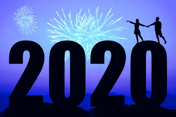 Noche azul con fuegos artificiales y año nuevo 2020 y pareja que apunta —  Fotos de Stock