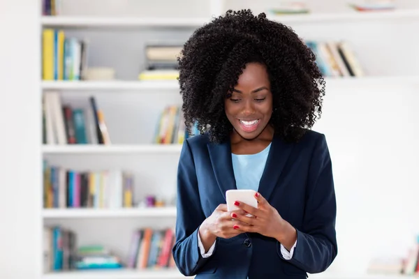 Femme d'affaires afro-américaine envoyant un message avec téléphone portable — Photo