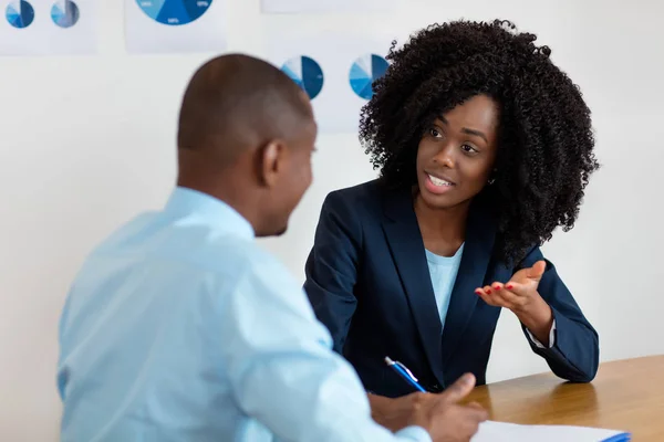 Afro-americana donna d'affari parlando con il cliente su contr — Foto Stock