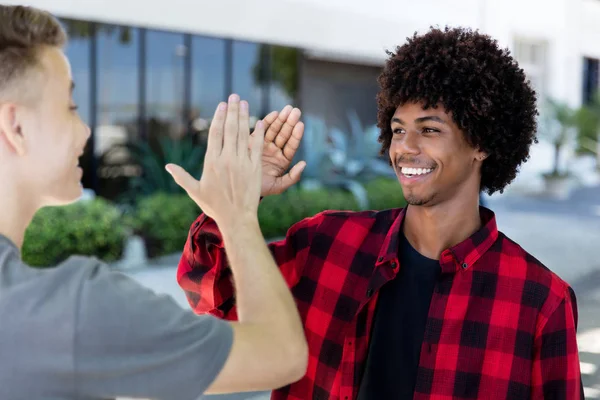 High five av afrikansk amerikansk man med ung vuxen vän — Stockfoto
