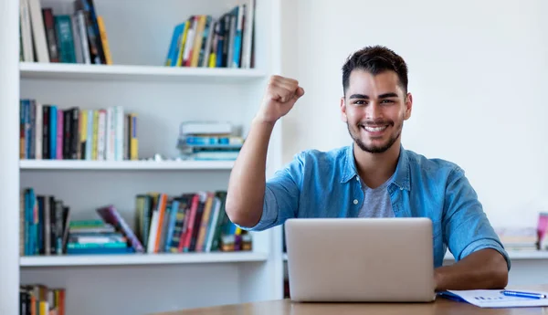 Jubelnder mexikanischer Hipster beim Online-Shopping mit dem Computer — Stockfoto