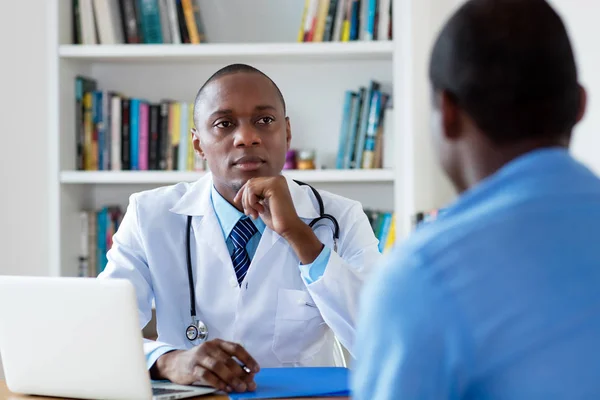 Африканський лікар - американець слухає проблеми пацієнта - чоловіка. — стокове фото